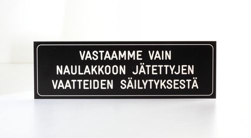 Vastaamme vain naulakkoon jätettyjen vaatteiden säilytyksestä -kilpi 25 x 8 cm POISTUVA MALLI